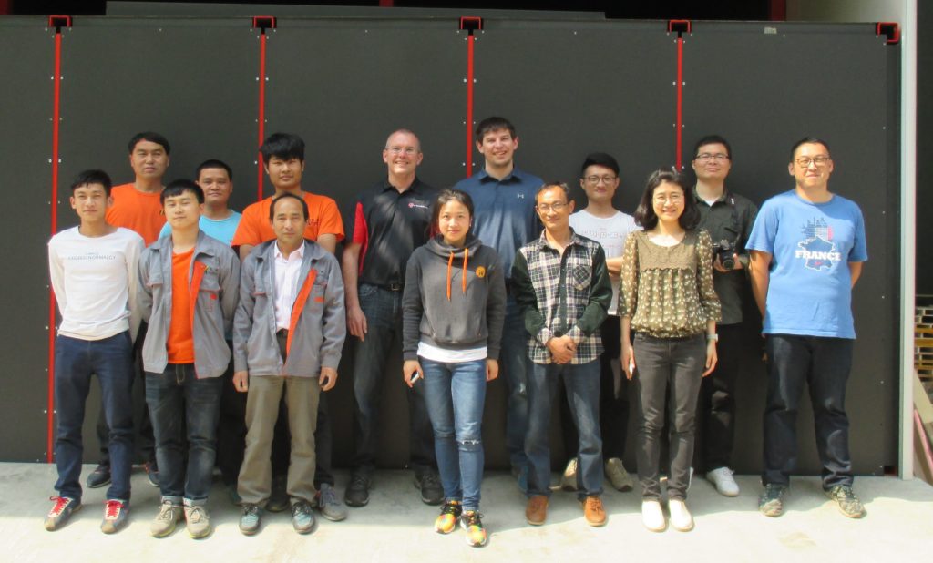 Group of GDUT students and LSPT engineers standing in front of completed laser peening facility