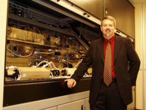 LSPT founder standing in front of laser system