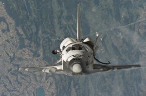 Space shuttle in orbit with earth backdrop