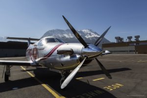 nose of propeller plane with mountain in background