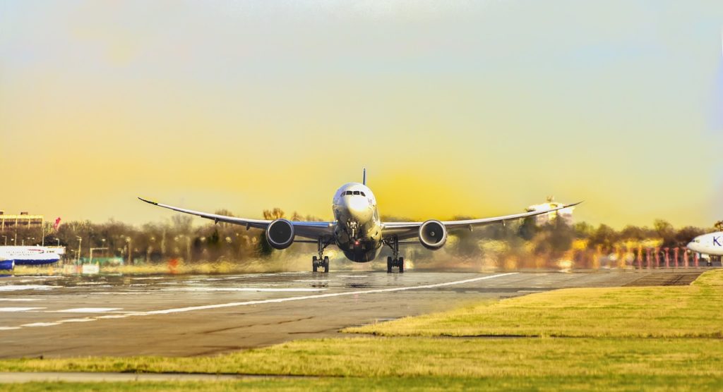 Commercial aircraft lifting off the runway on a clear, sunny day