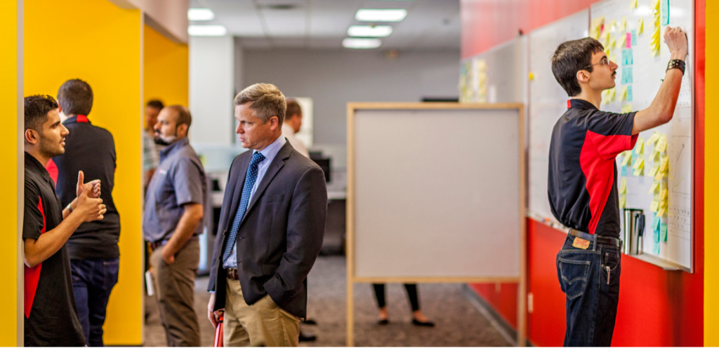 Automation Engineer Rohit Joshi, left, and Vice President of Engineering Mark Bloomberg take time to consider a problem from a different angle. Informal conversations fit the workstyle and speed the issue resolution process in huddle halls and open offices at the new headquarters of LSP Technologies.