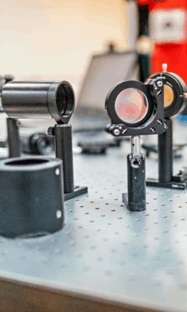 optics - Lenses on a laser table used for designing laser peening equipment custom solutions