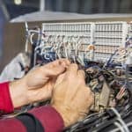 an employee fixing wires on a machine